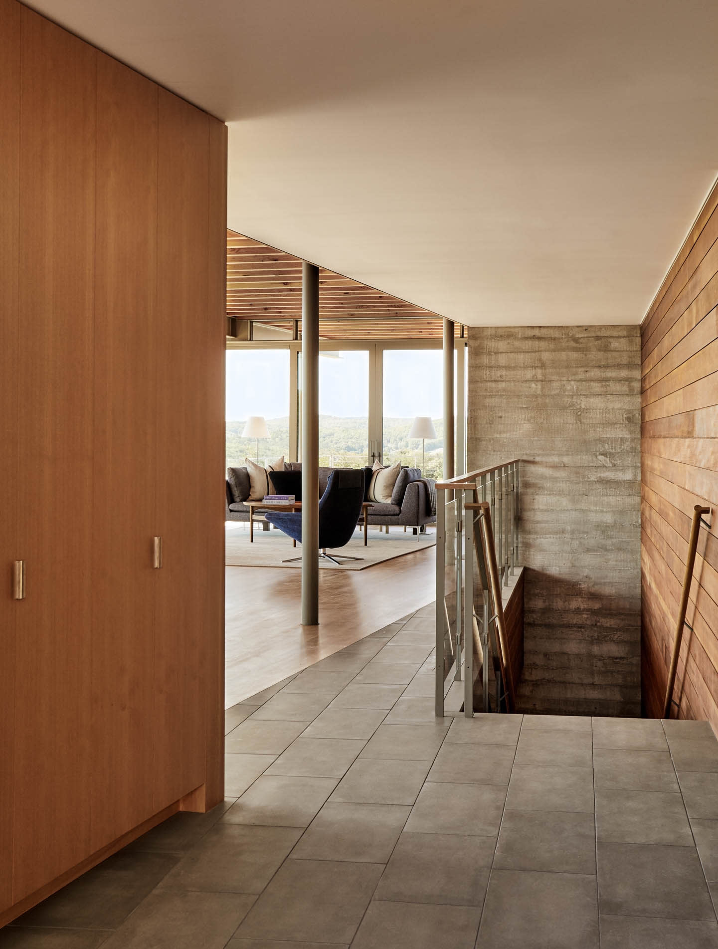 contemporary home with a wood wall lining the staircase up to a landing