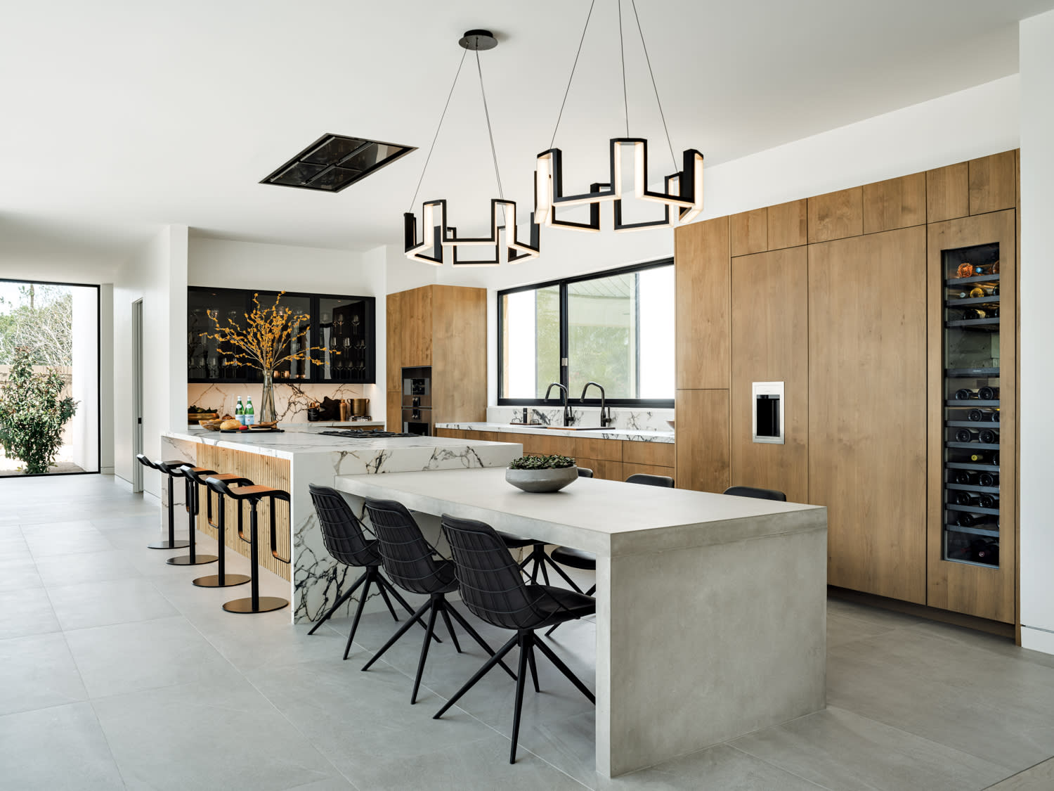 A modern kitchen with a large island and a large table.